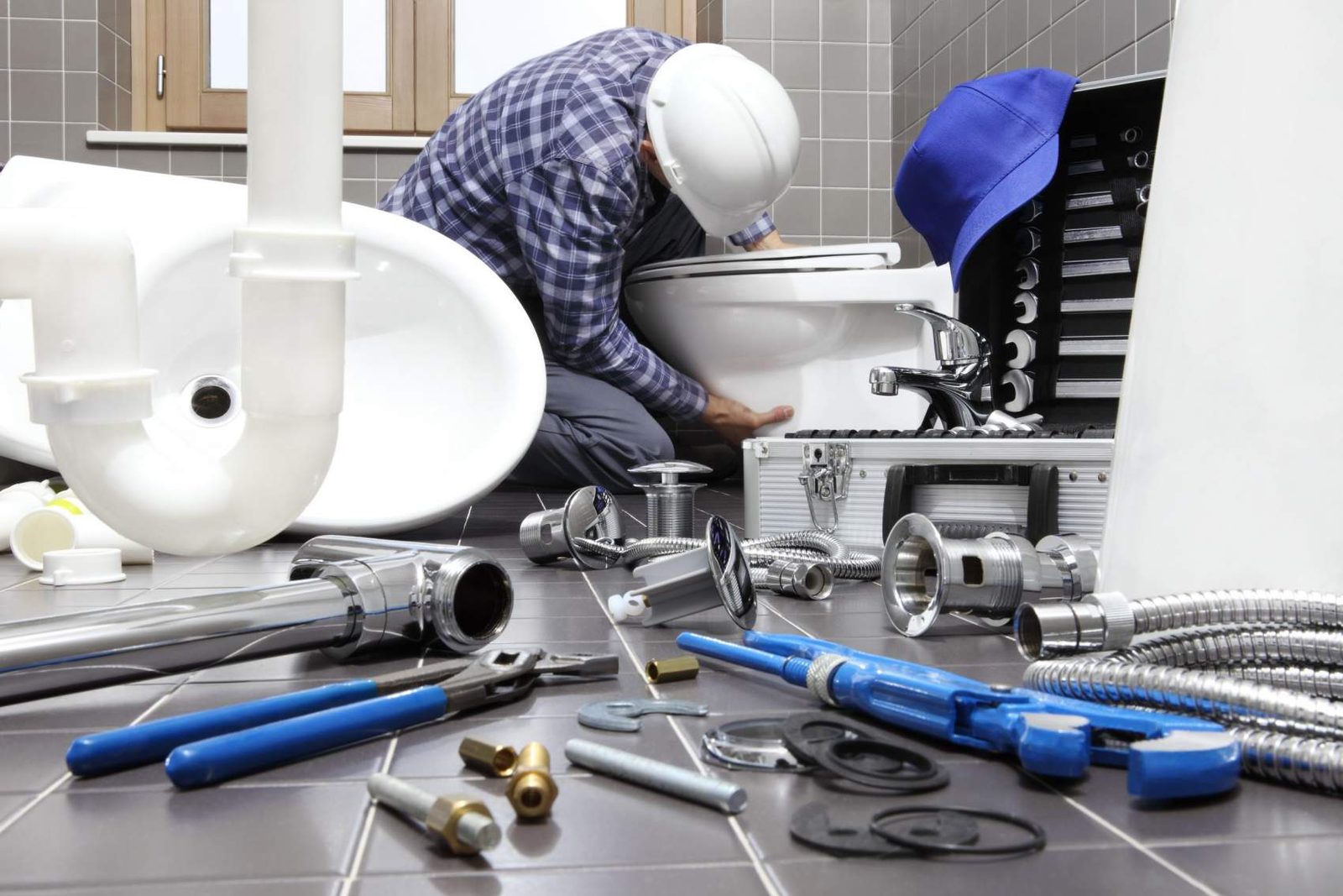 Flat lay of drain fittings, couplings and hand tools used on a Clog Busters truck