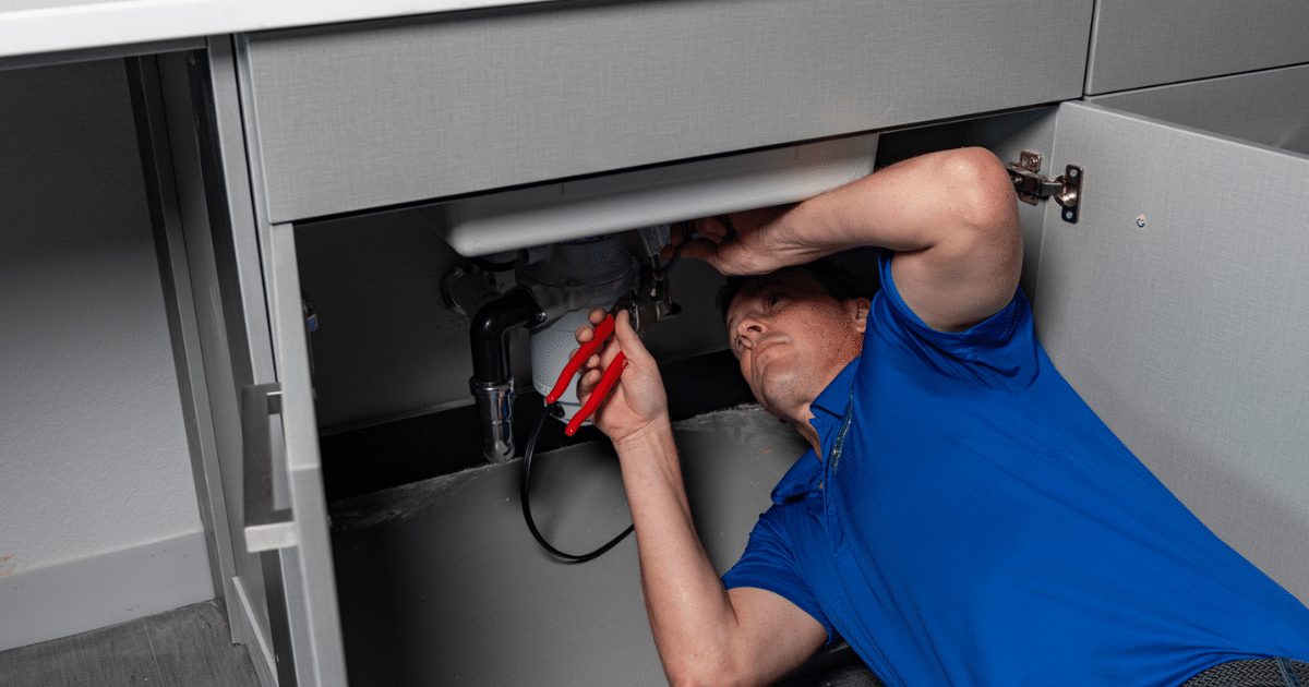 Clog Busters technician working under a kitchen sink
