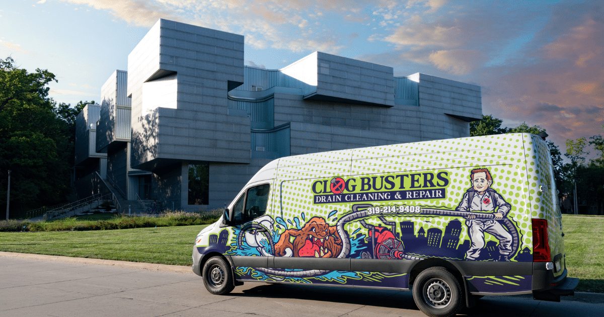Clog Busters van parked outside a building at dusk