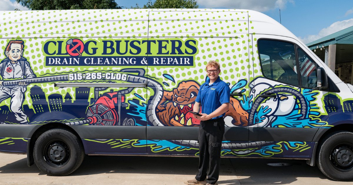 Clog Busters technician standing beside the open service van